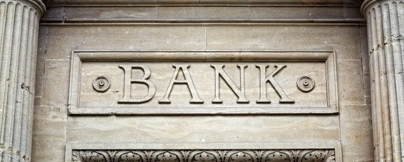 Old bank sign engraved in stone or concrete above the door of financial building concept for finance and business